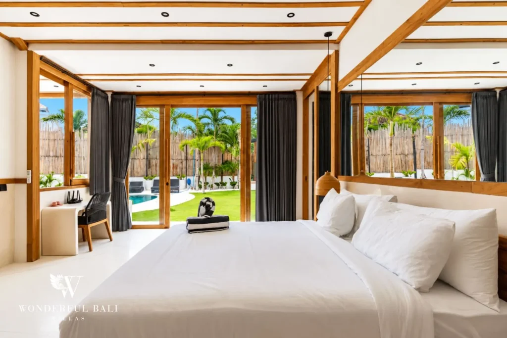 Master bedroom with picture window and garden view at family villa in Umalas, Bali