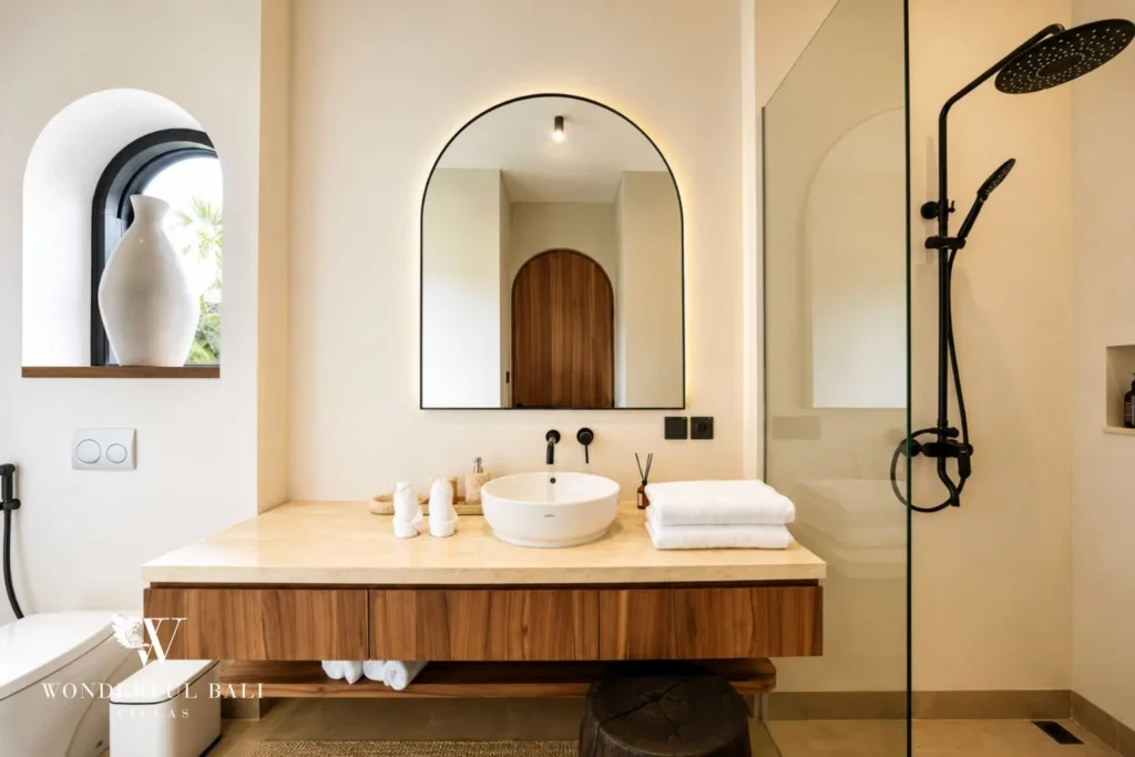 Bedroom in neutral tones with arches and plants at villa in Umalas, Bali