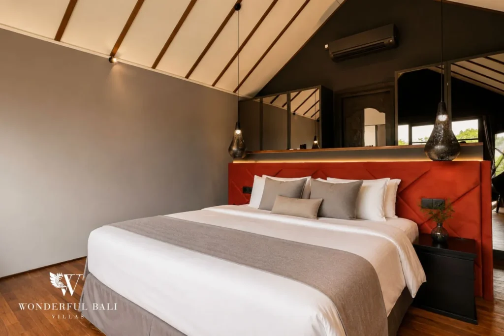 Bedroom with white bed, orange bench and pitched ceiling at villa in Umalas, Bali