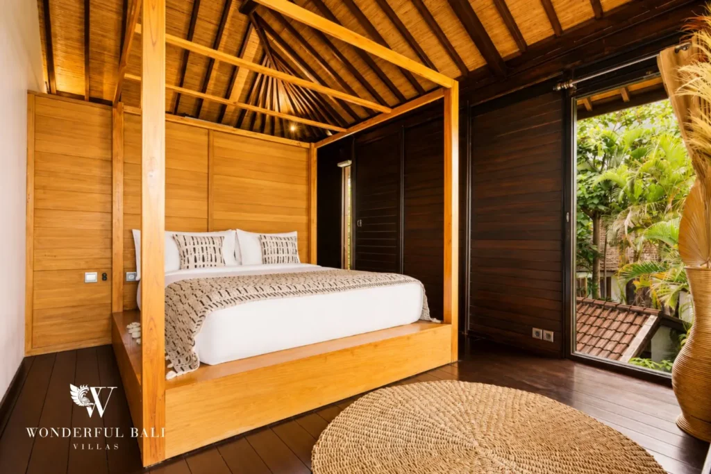 Bedroom with wooden bed, timber walls and garden window at villa in Umalas, Bali