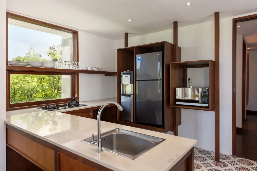 Kitchen with timber cabinetry and stone counter at villa in Batu Belig, Bali