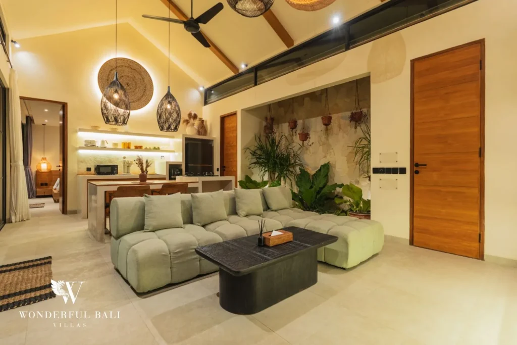 Living area with sofa, TV and stone feature wall at villa in Seseh, Bali