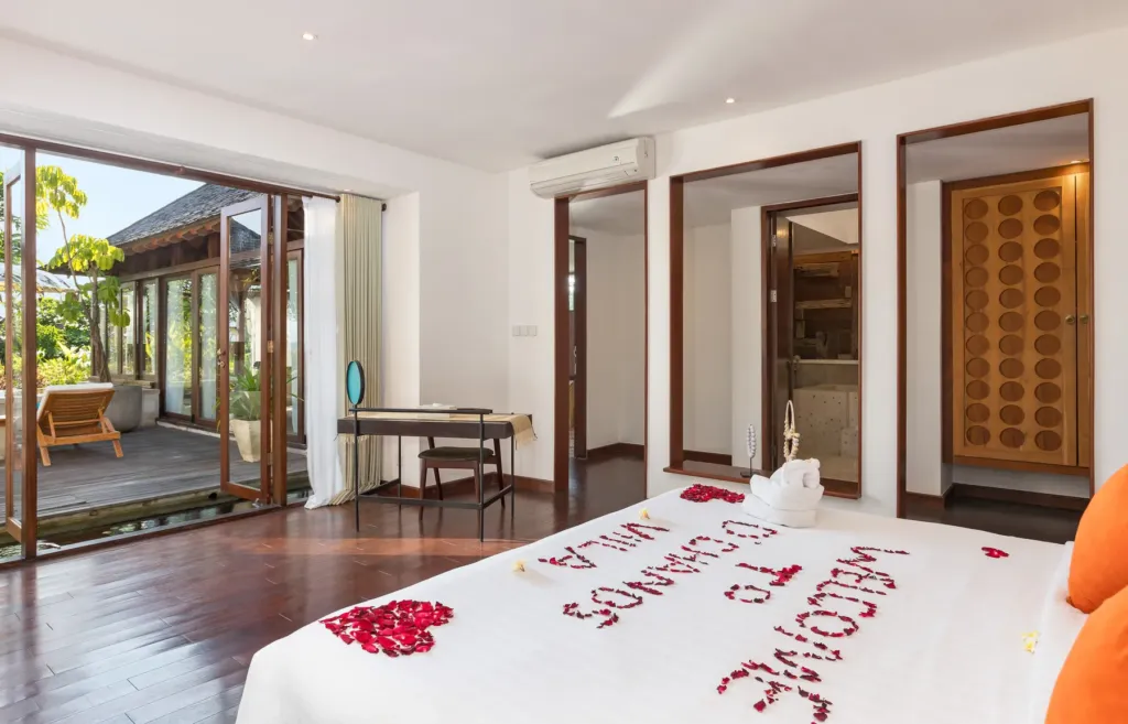 Master bedroom with king bed and rose-petal decor at villa in Batu Belig, Bali