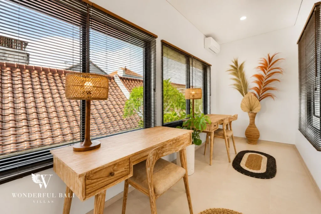 Open dining nook with timber table and large windows to the view at villa in Canggu, Bali