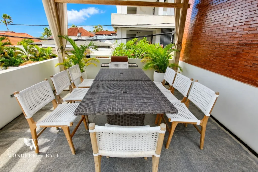Outdoor dining with long table and open rooftop view at villa in Berawa, Bali