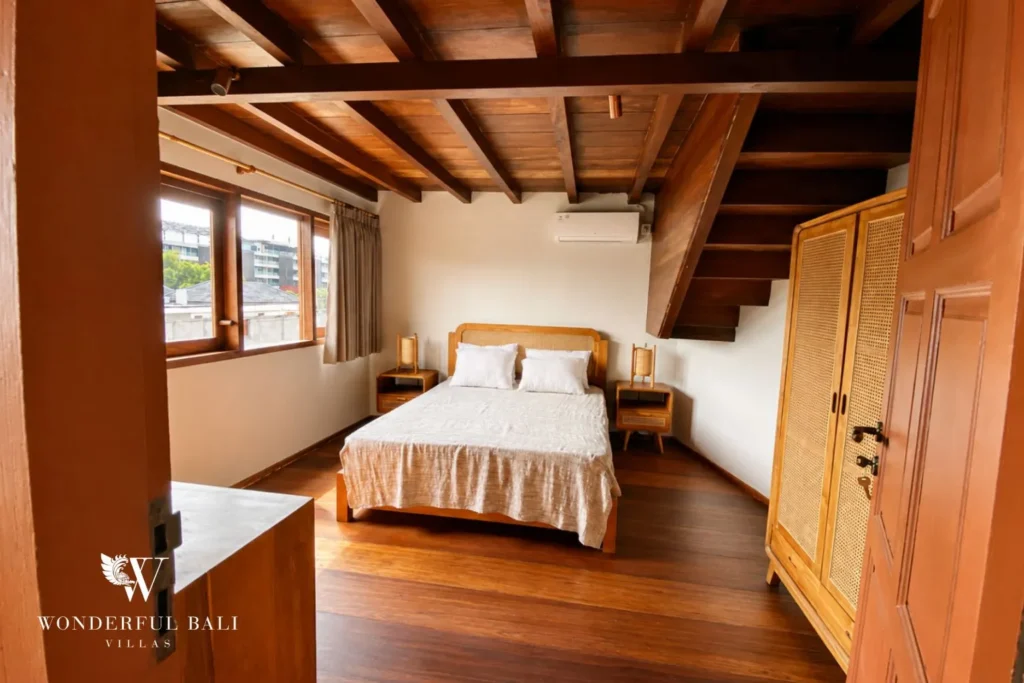 Bedroom with timber bed, thatched ceiling and wardrobe at villa in Bumbak, Bali