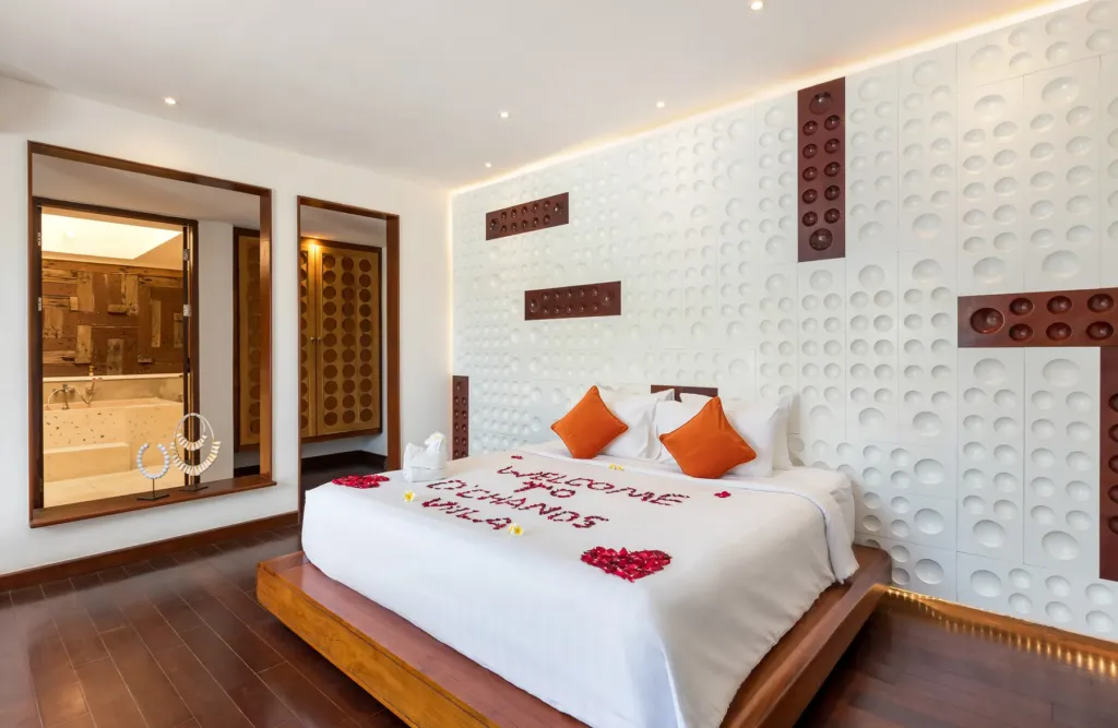 Master bedroom with king bed and orange accents at villa in Batu Belig, Bali