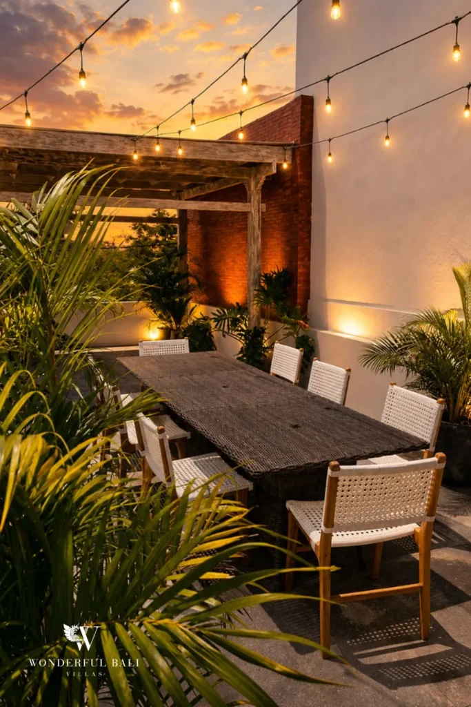 Outdoor dining at night with long table and string lights at villa in Berawa, Bali