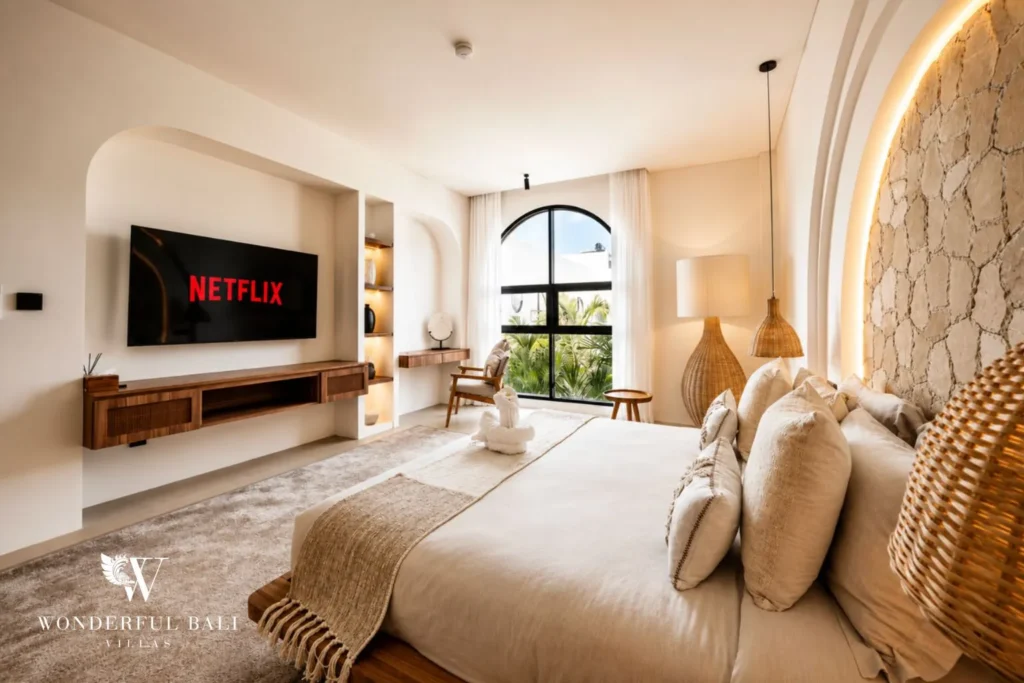 Bedroom with TV niche and curved plaster walls at villa in Umalas, Bali