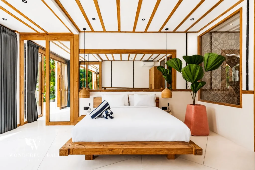 Four-poster bedroom with terracotta accent wall at family villa in Umalas, Bali