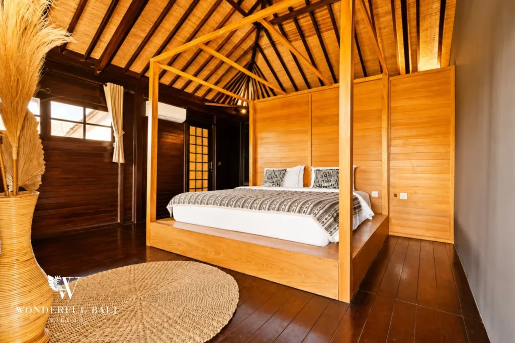 Bedroom with timber four-poster bed against a panelled wall at villa in Umalas, Bali