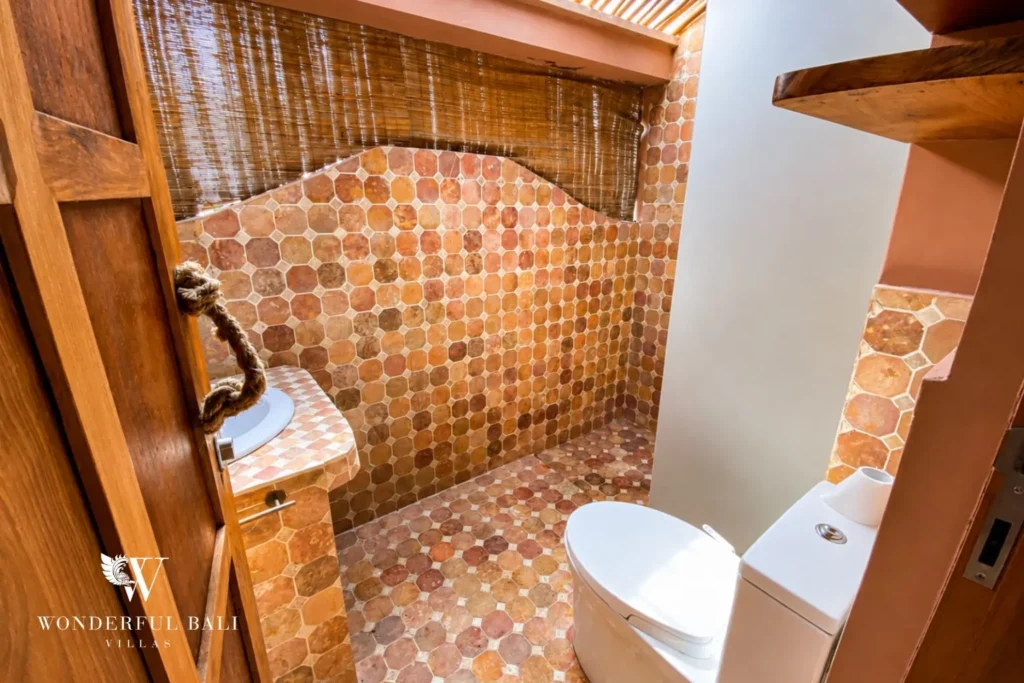 Terracotta-tiled bathroom with bathtub and walk-in shower at villa in Bumbak, Bali