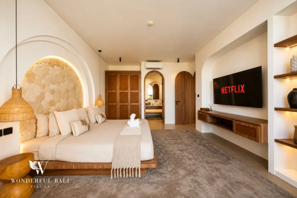 Bedroom with arched detailing and built-in shelving at villa in Umalas, Bali