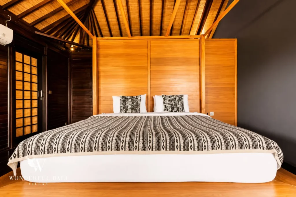 Bedroom with king bed and timber feature wall at villa in Umalas, Bali