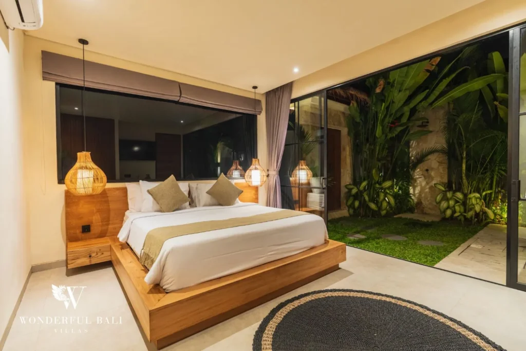 Bedroom with patterned tile wall, woven decor and mood lighting at villa in Seseh, Bali