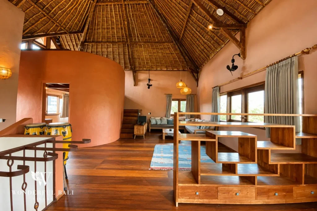 Upstairs loft landing with thatched roof and seating at villa in Bumbak, Bali
