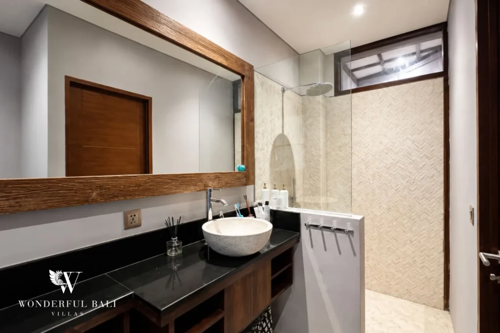 Bathroom with double vanity, black counter and mirror at villa in Umalas, Bali