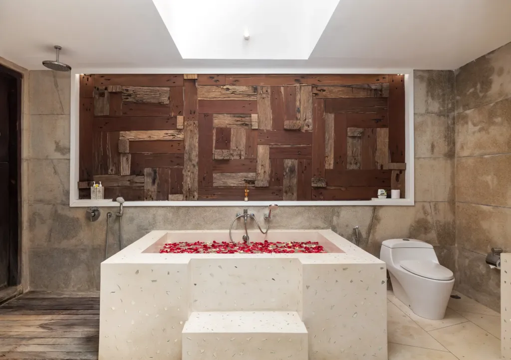 Ensuite bathroom with bathtub and rose-petal decor at villa in Batu Belig, Bali