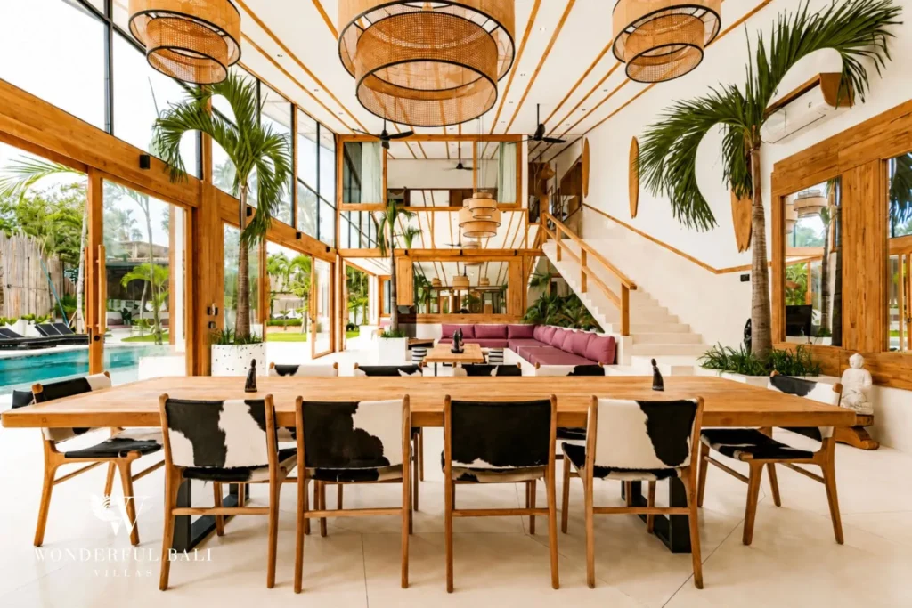 Indoor dining with long table and tropical plants at family villa in Umalas, Bali