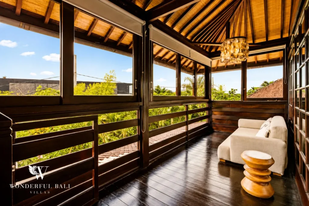 Upstairs open-air lounge with daybed and garden view at villa in Umalas, Bali