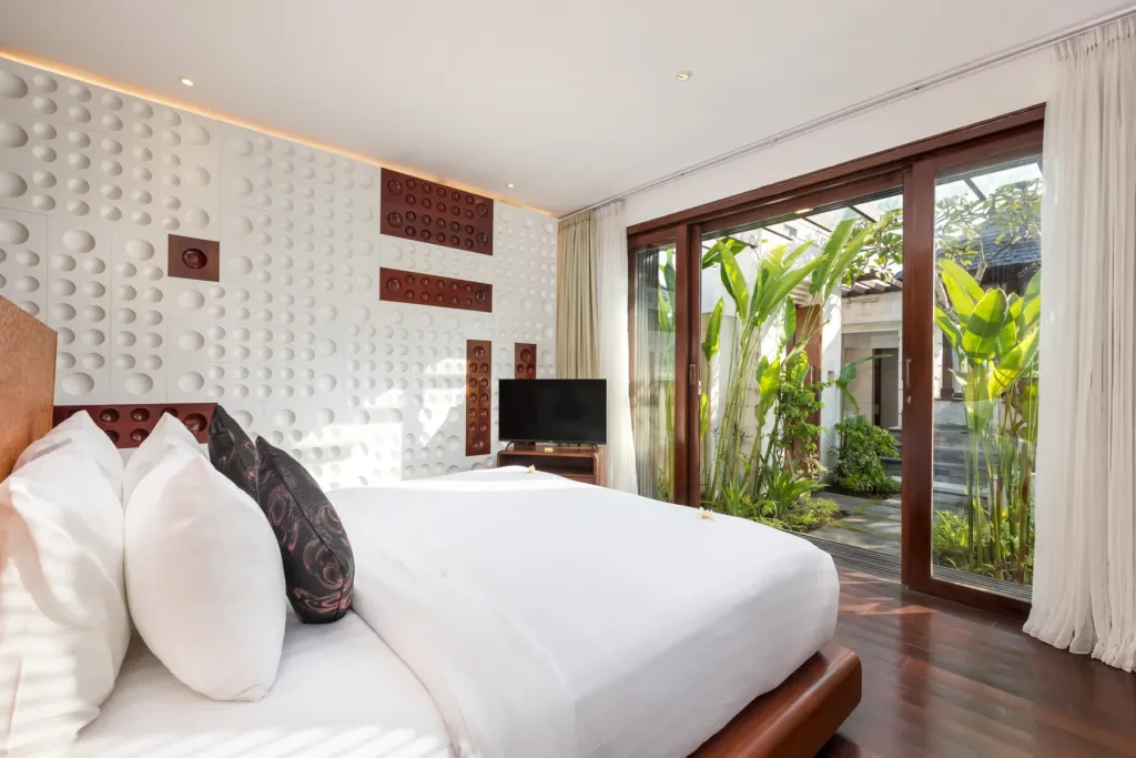 Second bedroom with king bed and white linens at villa in Batu Belig, Bali