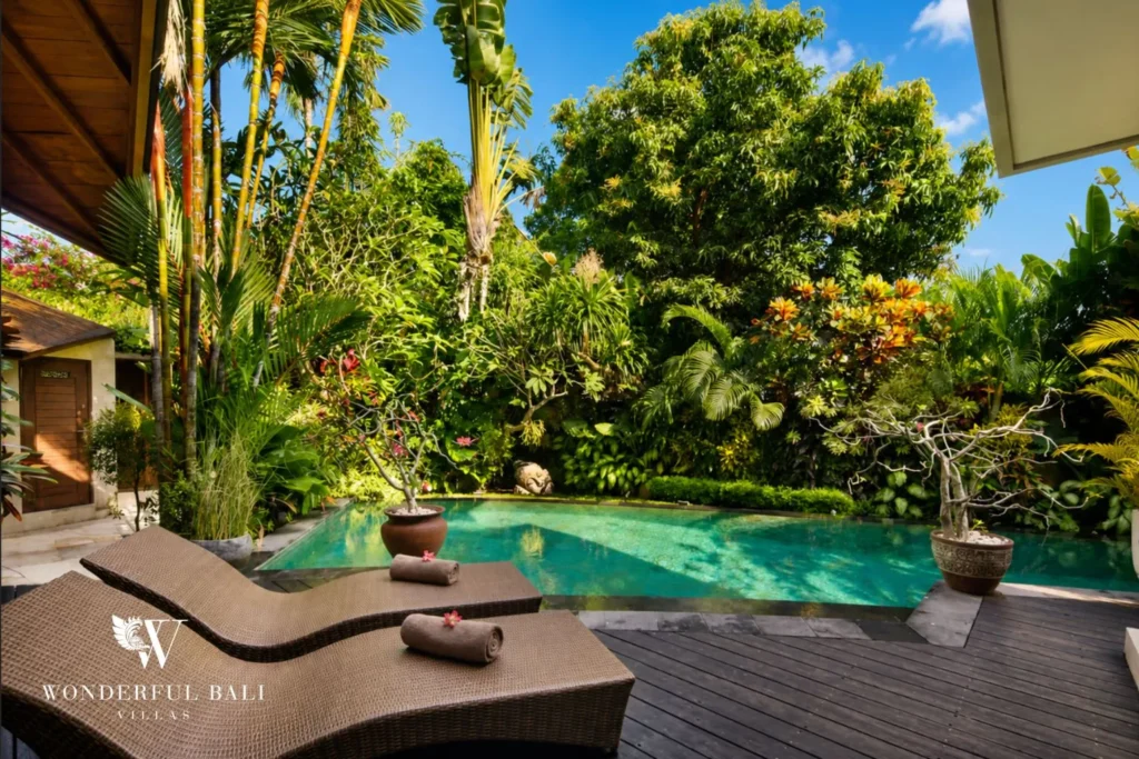 Pool with sun loungers beside a tropical garden at villa in Umalas, Bali