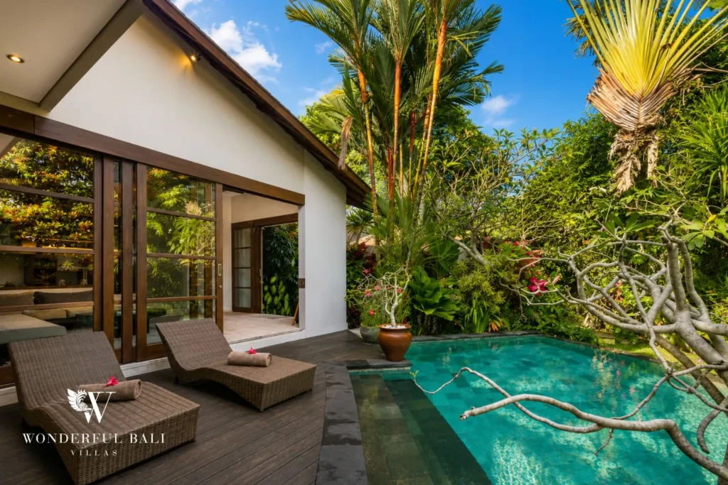 Pool and villa with garden from a side view at villa in Umalas, Bali
