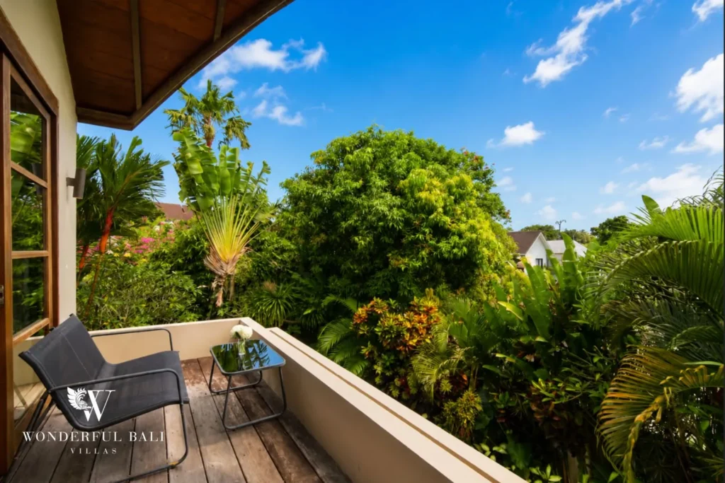 Pool deck with sun loungers and garden view at villa in Umalas, Bali