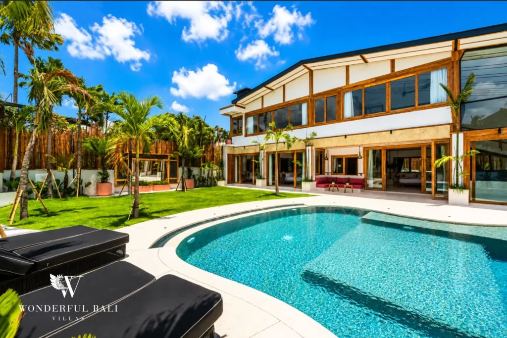 Pool, garden lawn and villa facade at family villa in Umalas, Bali
