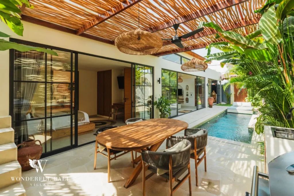 Outdoor dining under a bamboo roof with pool view at villa in Seseh, Bali