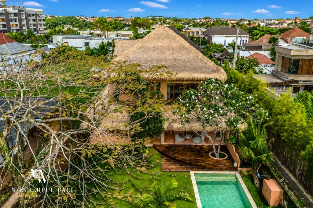 Aerial view of thatched roofs, pool and garden at villa in Bumbak, Bali