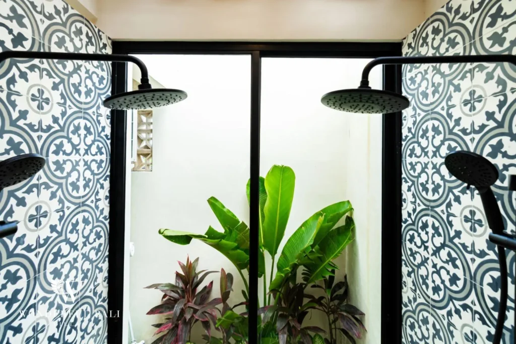 Outdoor shower with patterned tile and plants at villa in Seseh, Bali