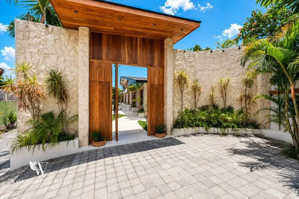 Timber pivot door and stone entrance gateway at family villa in Umalas, Bali