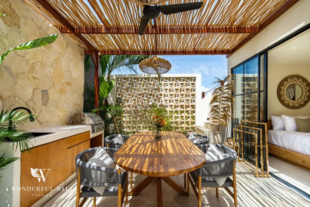 Outdoor dining with round table under a bamboo roof at villa in Seseh, Bali