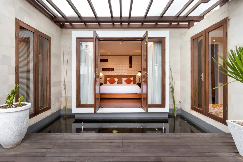 Bedroom with carved timber door detail at villa in Batu Belig, Bali