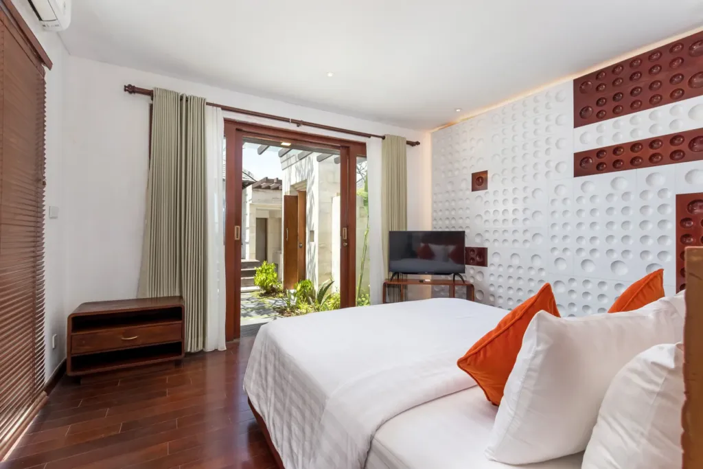 Second bedroom with orange accents and timber detailing at villa in Batu Belig, Bali