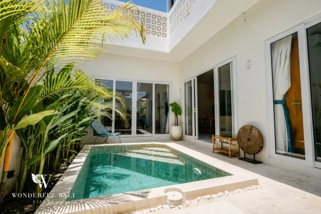 Green-tiled courtyard plunge pool framed by palms at a 2-bedroom villa in Cemagi Bali