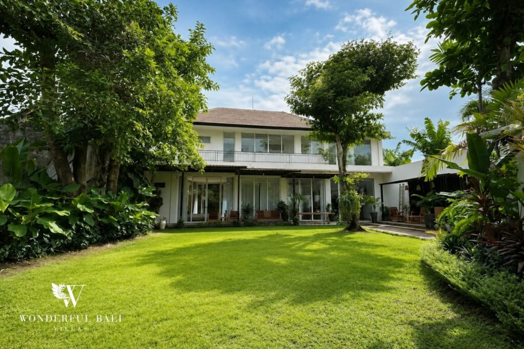 Large tropical garden and lawn with the villa beyond at a villa in Seminyak