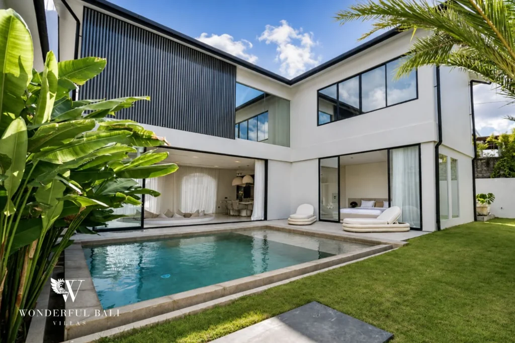 Private pool and tropical garden of a modern 3-bedroom villa in Umalas, Bali, with sun loungers and open living pavilion