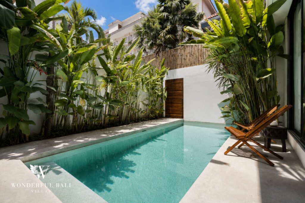 Private pool with sun loungers and tropical planting at a villa in Petitenget, Seminyak