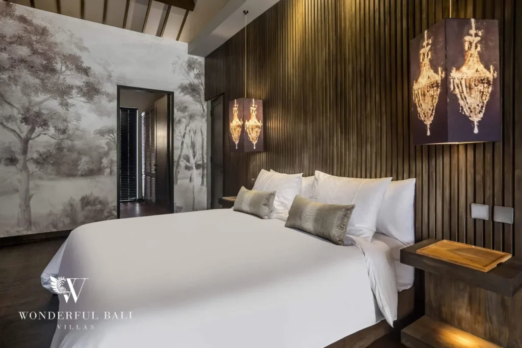 A bedroom with a white-linen bed against a slatted wood wall, illuminated art panels and a painted forest mural at a 3-bedroom villa in Pererenan, Bali
