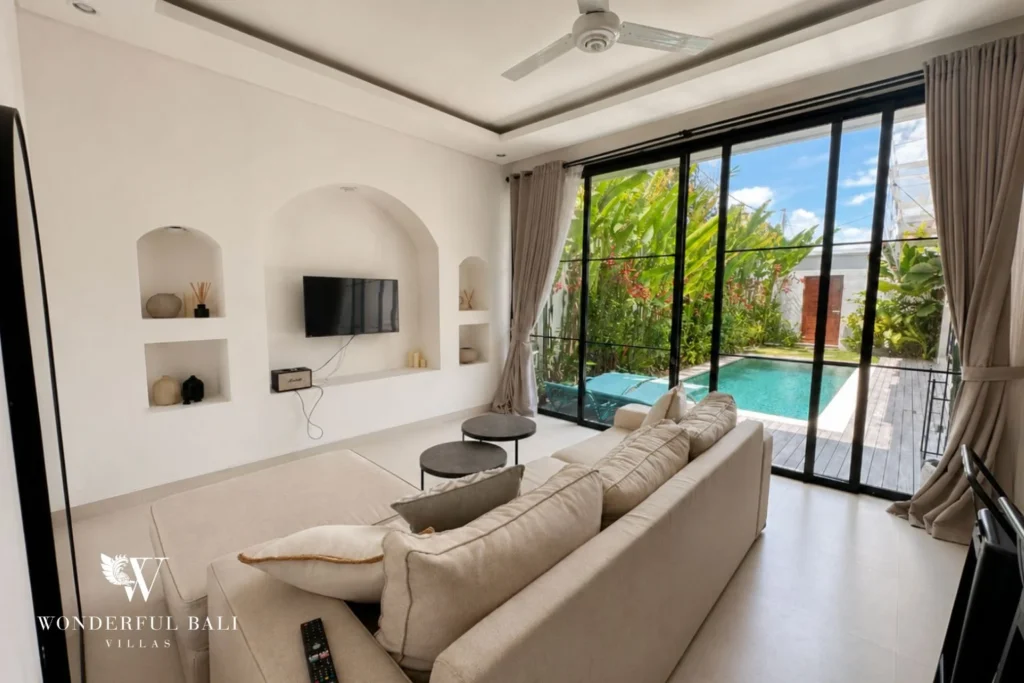 Living room with arched wall niches and pool view in a 2-bedroom villa in Seseh Bali