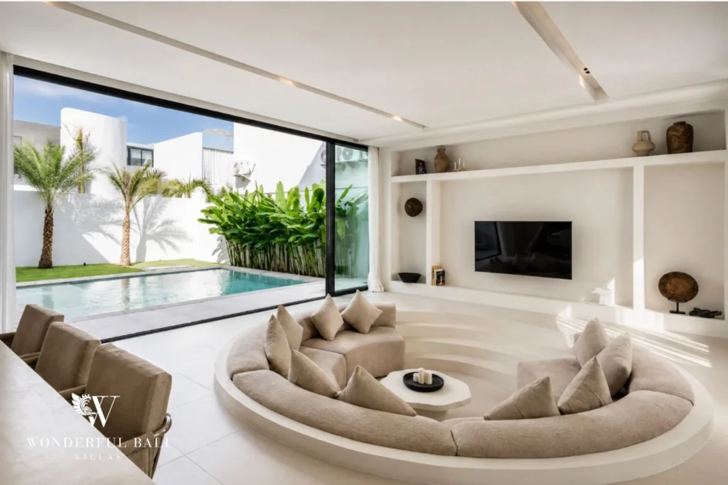 Sunken circular lounge with wall-mounted TV opening to the pool at a modern villa in Umalas, Bali