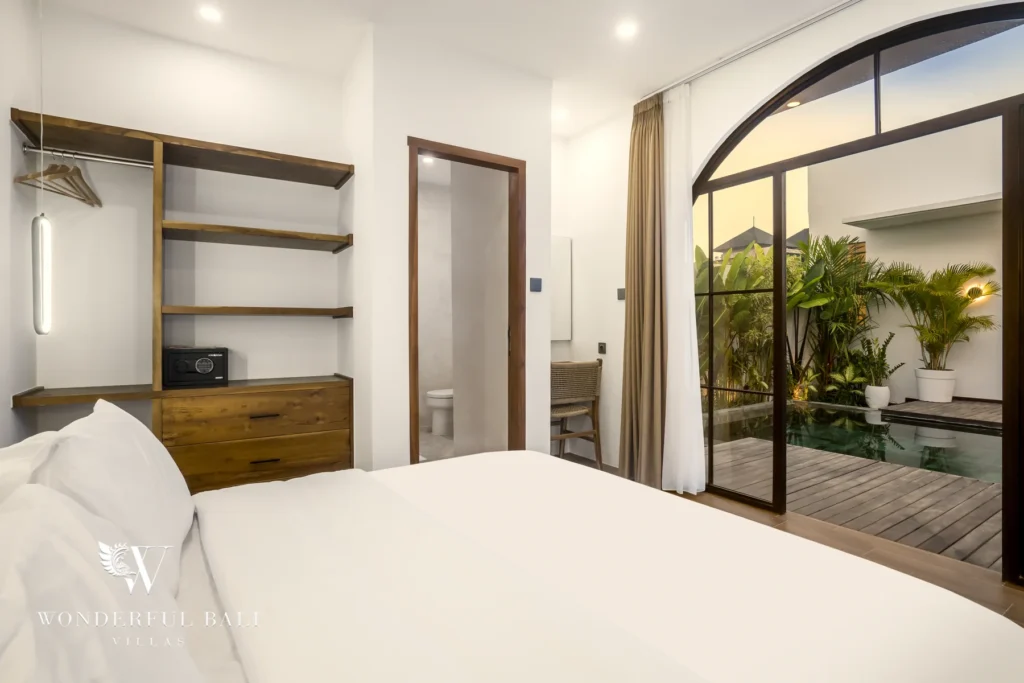 Bedroom with open wardrobe and ensuite bathroom at a 3-bedroom villa in Pererenan, Bali