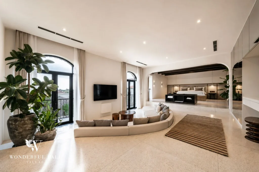 Upstairs master suite with curved sofa and bed on a raised platform in a 4-bedroom villa in Canggu Bali