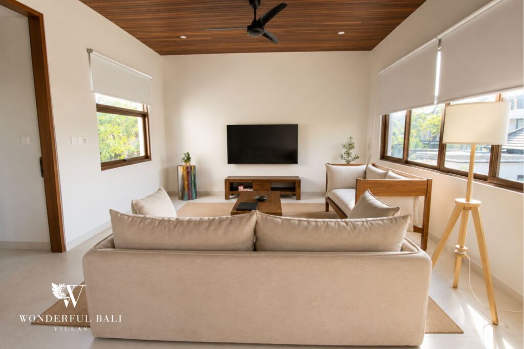 Open-plan living room with sofa and full-height glazing at a villa in Berawa, Canggu