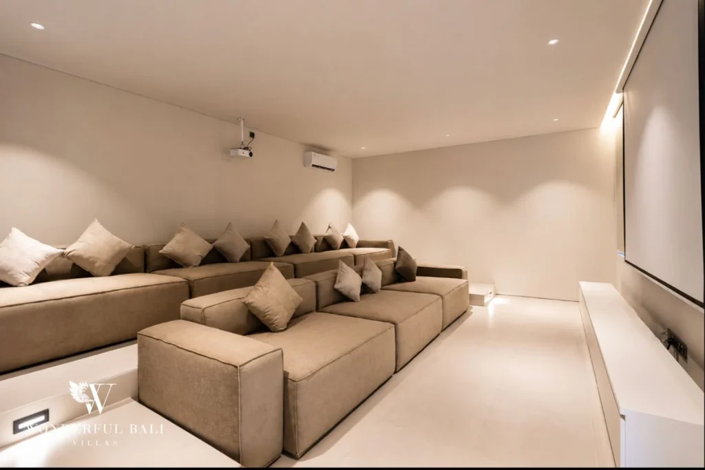 Private cinema room with tiered sofa seating and projector screen at a modern 3-bedroom villa in Umalas, Bali