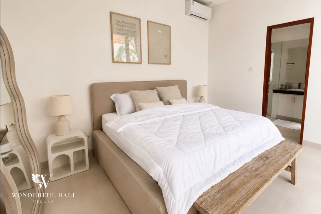 Air-conditioned bedroom with upholstered headboard and en-suite bathroom in a 2-bedroom villa in Seseh Bali