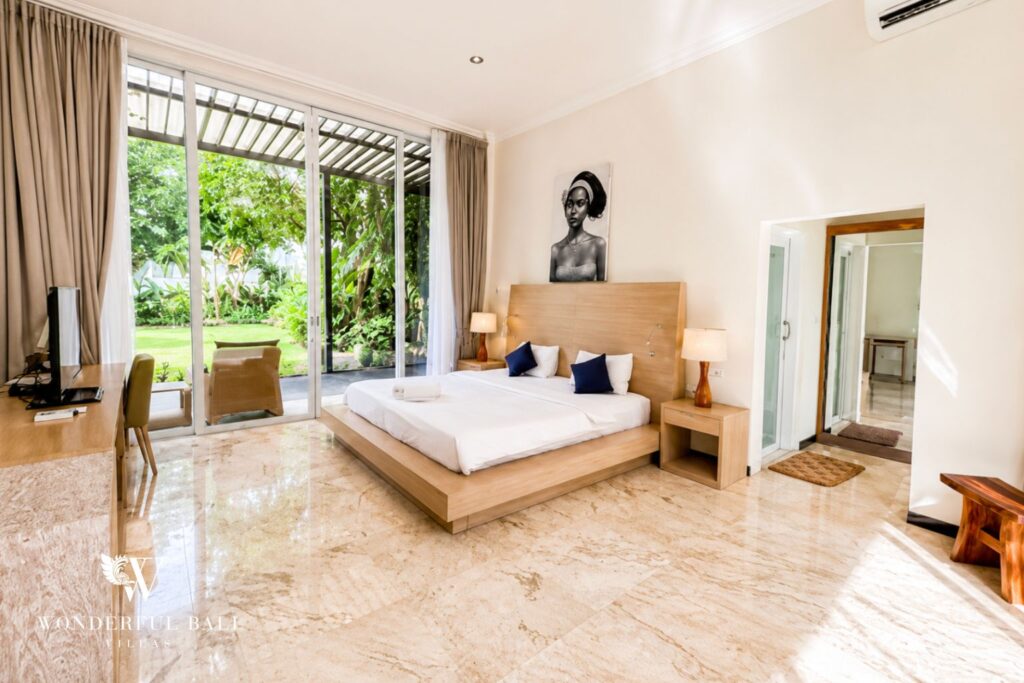 Bedroom with king bed and framed artwork at a villa in Seminyak