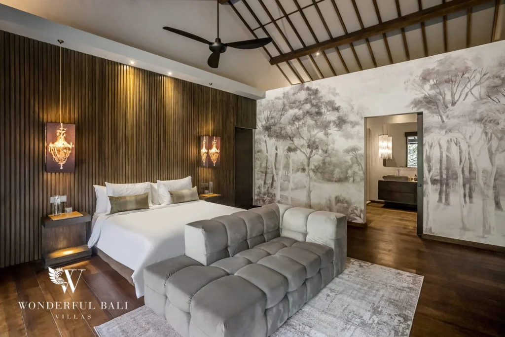 Bedroom with a king bed, wood-slat wall, chandelier sconces, vaulted ceiling and ensuite view at a 2-bedroom villa in Pererenan, Bali